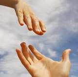 Hands coming together to touch with sky background